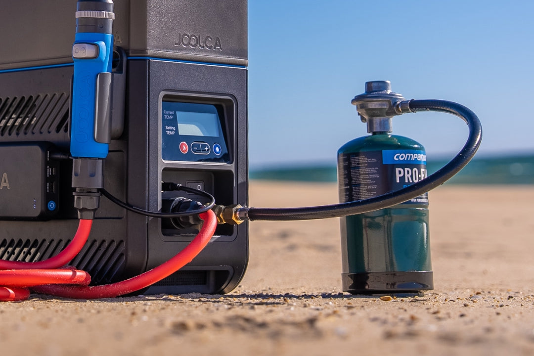 HOTTAP Go on a beach, connected by its quick-connect gas hose to a small gas canister