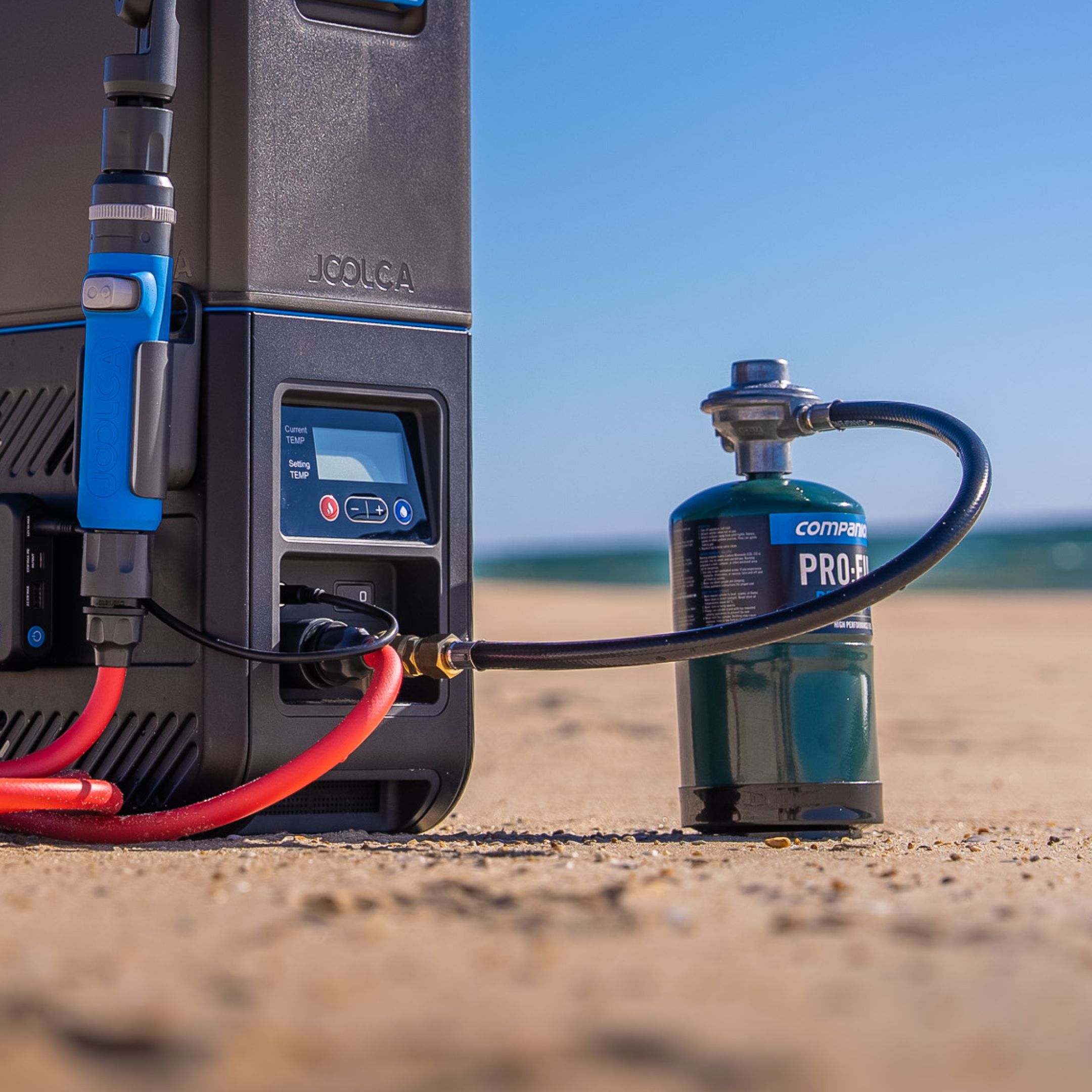 HOTTAP Go on a beach with its quick-connect gas hose linked to a small Companion gas canister