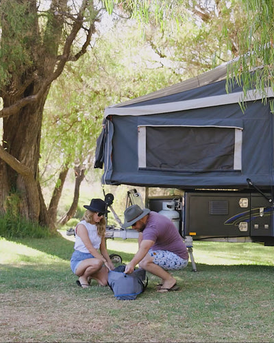 Family setting up the Joolca Ensuite Double shower tent outdoors on grass