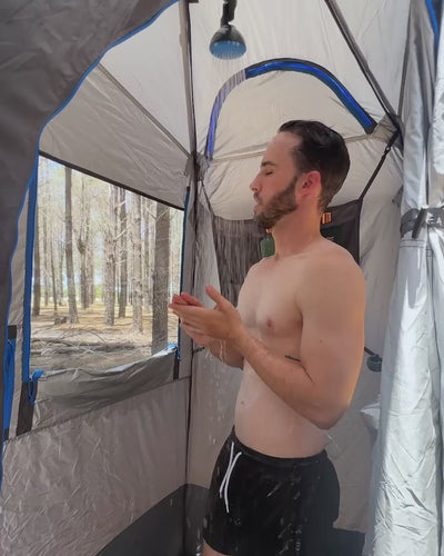 Man standing inside the Joolca Ensuite Double tent, seen through the striped privacy door