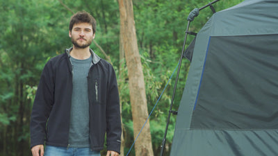 Man rinsing shampoo from his hair inside the Joolca Ensuite Double shower tent, smiling.